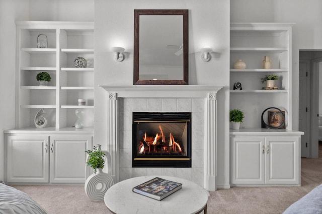 living room with built in features, light carpet, and a fireplace