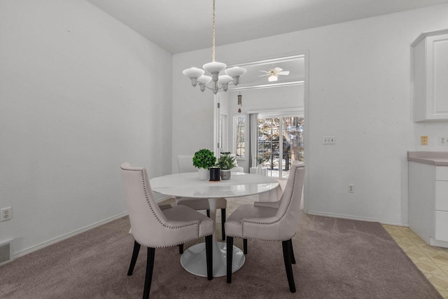 dining room with ceiling fan with notable chandelier and light colored carpet