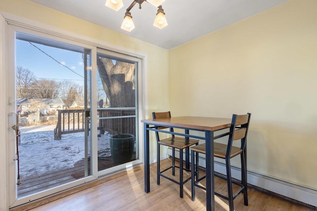 dining room with baseboard heating and hardwood / wood-style flooring