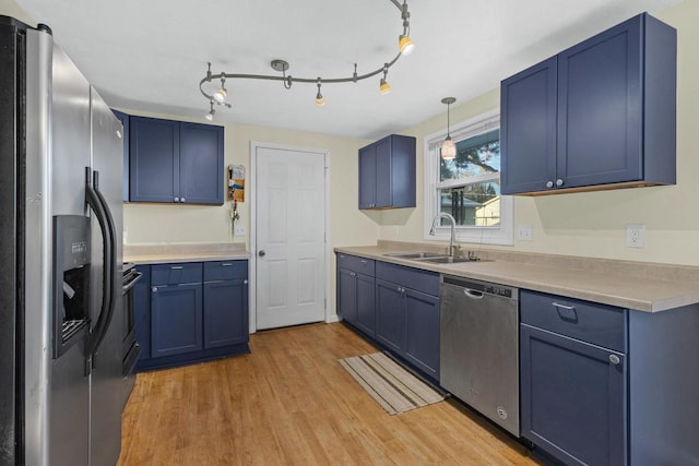 kitchen featuring light hardwood / wood-style flooring, hanging light fixtures, stainless steel appliances, blue cabinets, and sink