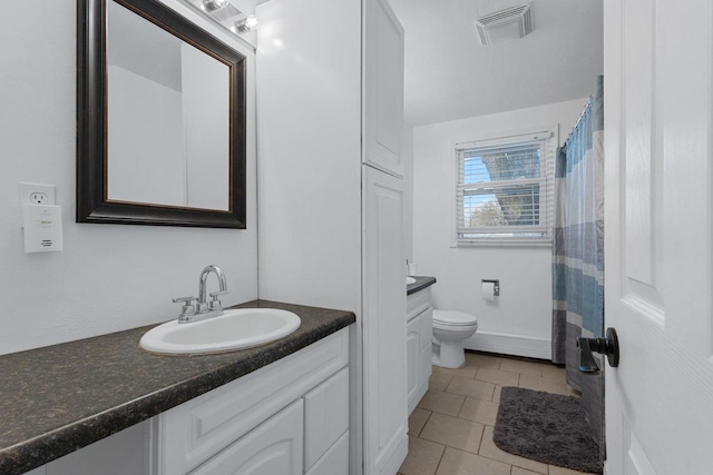 bathroom with toilet, vanity, and tile patterned floors