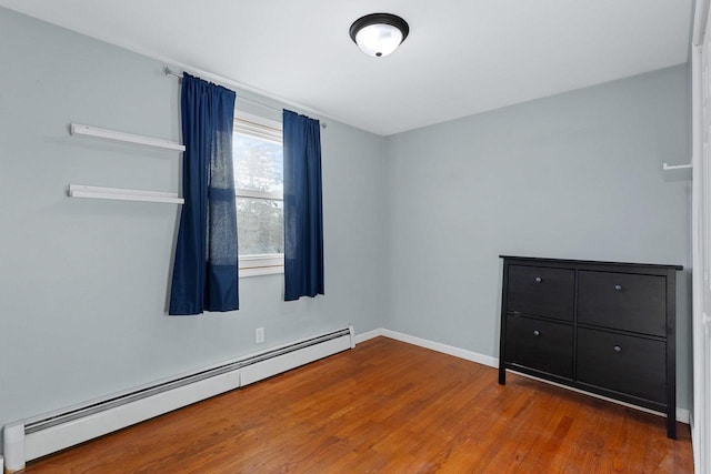 spare room with a baseboard radiator and wood-type flooring