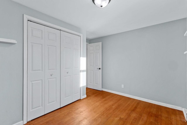 unfurnished bedroom featuring light wood-type flooring and a closet