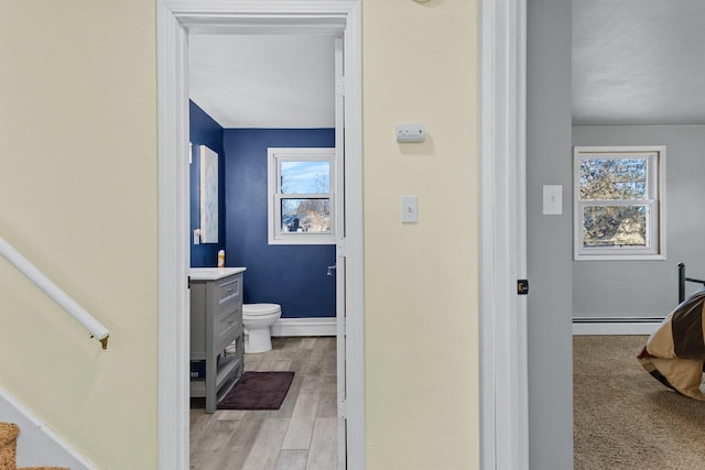 bathroom with vanity, a baseboard radiator, toilet, and plenty of natural light