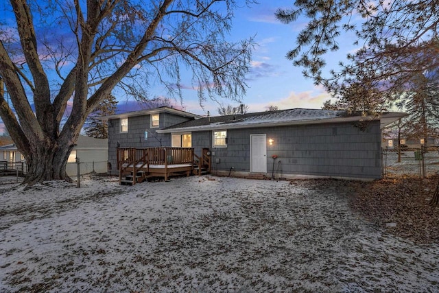 back house at dusk with a wooden deck