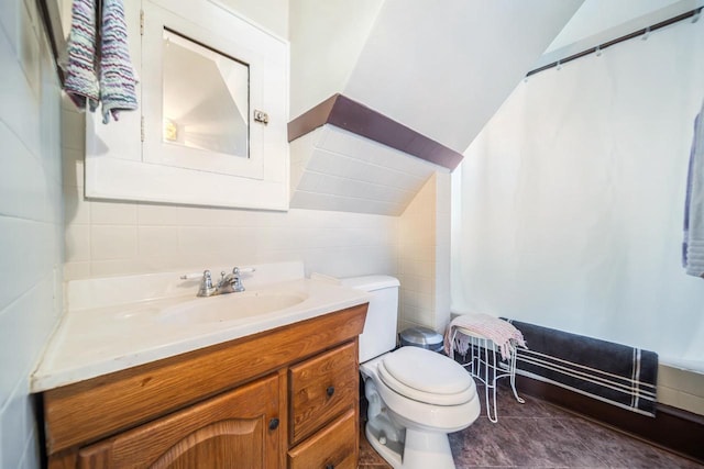 bathroom with lofted ceiling, vanity, and toilet