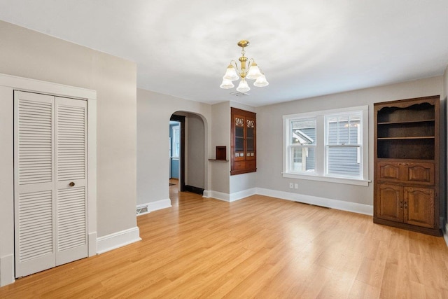 unfurnished living room with light hardwood / wood-style floors and an inviting chandelier