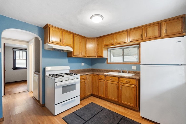 kitchen featuring white appliances, light hardwood / wood-style floors, and sink