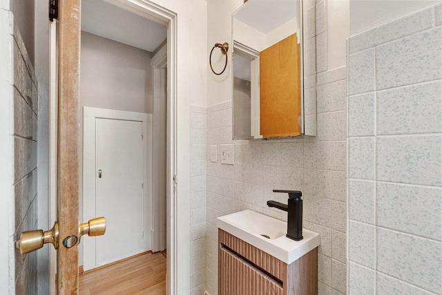 bathroom featuring vanity, tile walls, and hardwood / wood-style flooring