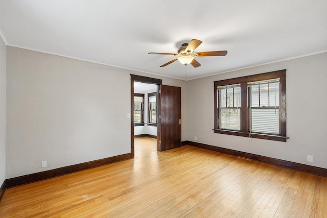 spare room with ornamental molding, ceiling fan, and light wood-type flooring