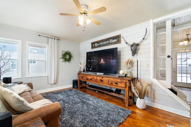 living room with wood-type flooring, ceiling fan, and a healthy amount of sunlight