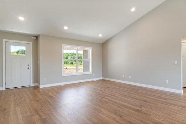 entrance foyer featuring lofted ceiling and light hardwood / wood-style floors