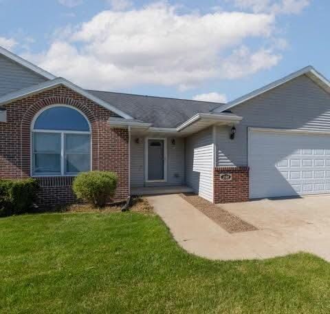 ranch-style home with a front lawn and a garage