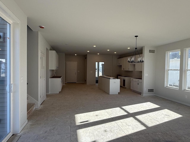 kitchen featuring a chandelier, white cabinets, and decorative light fixtures