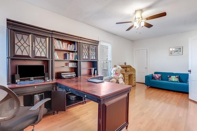 home office with light wood-type flooring and ceiling fan