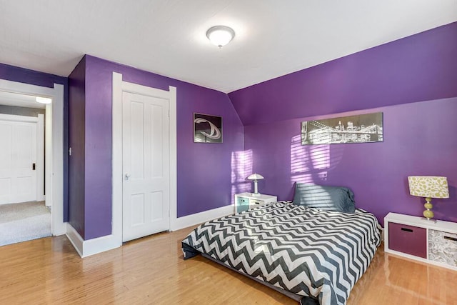 bedroom with hardwood / wood-style flooring and vaulted ceiling