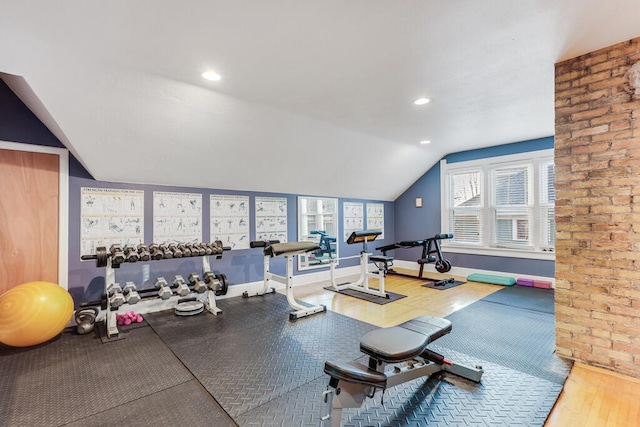 exercise room featuring lofted ceiling and hardwood / wood-style floors