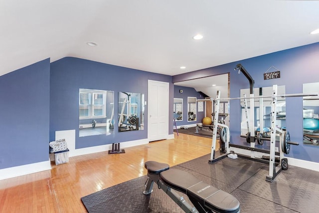 workout area featuring hardwood / wood-style floors and vaulted ceiling