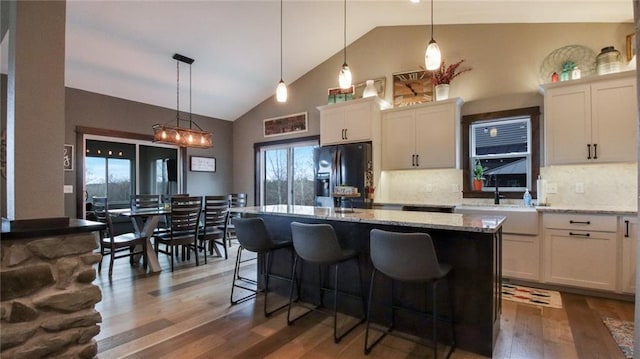 E5695 510th Ave, Menomonie, WI 54751 - kitchen featuring pendant lighting, dark hardwood / wood-style floors, a center island, backsplash, and fridge with ice dispenser