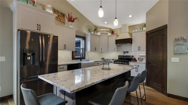 E5695 510th Ave, Menomonie, WI 54751 - kitchen featuring a center island, custom range hood, fridge with ice dispenser, stove, and sink