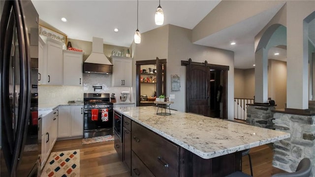 E5695 510th Ave, Menomonie, WI 54751 - kitchen with stainless steel appliances, white cabinets, a center island, custom range hood, and a barn door
