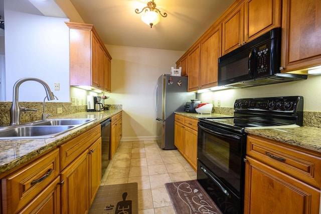 kitchen with sink, light tile patterned floors, black appliances, and light stone countertops