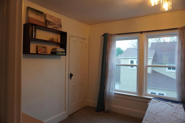 entryway with crown molding and carpet floors