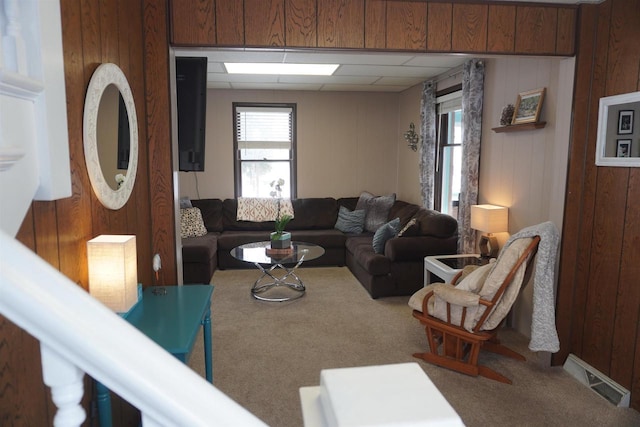 carpeted living room featuring wooden walls