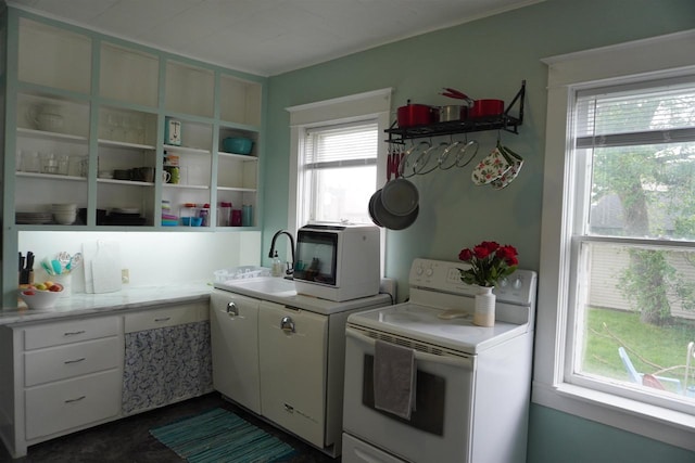 kitchen featuring sink, white appliances, and white cabinetry