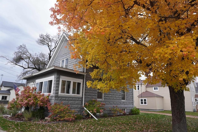 view of property hidden behind natural elements with a front yard