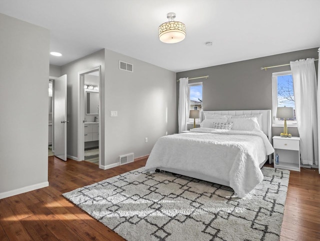 bedroom featuring dark hardwood / wood-style flooring and ensuite bathroom