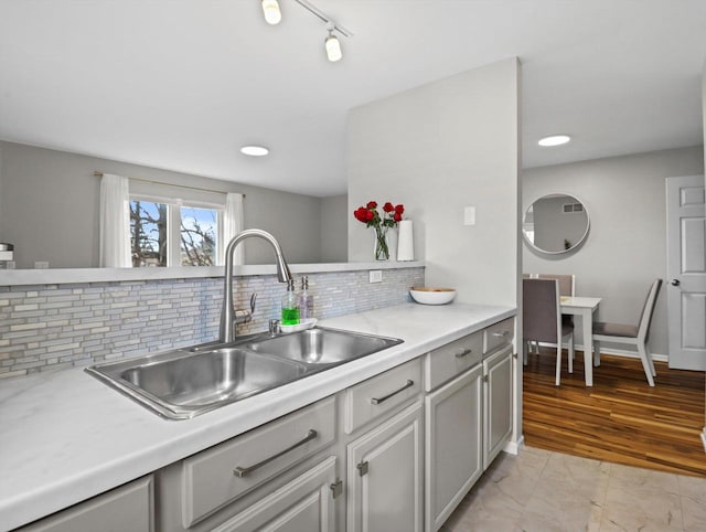 kitchen with sink, rail lighting, and decorative backsplash