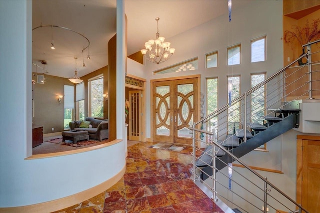 entrance foyer featuring a notable chandelier, french doors, and a towering ceiling