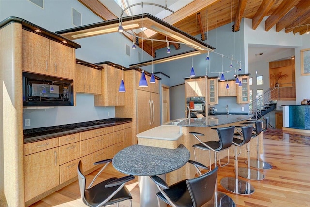 kitchen with built in appliances, high vaulted ceiling, light wood-type flooring, beam ceiling, and wooden ceiling