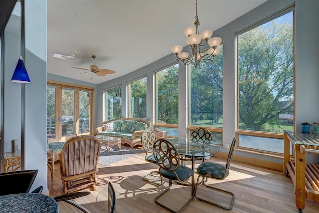 sunroom featuring lofted ceiling and ceiling fan with notable chandelier