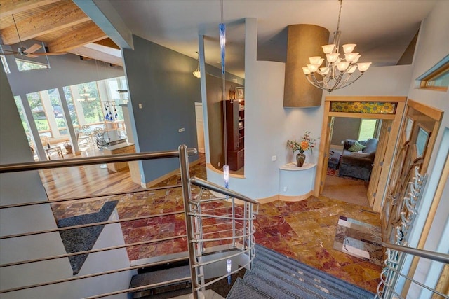 stairs featuring wood ceiling, vaulted ceiling with beams, and ceiling fan with notable chandelier