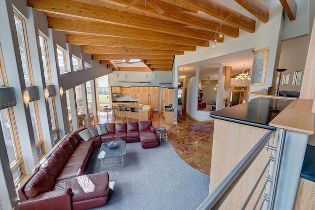 living room with a notable chandelier, carpet floors, and beamed ceiling