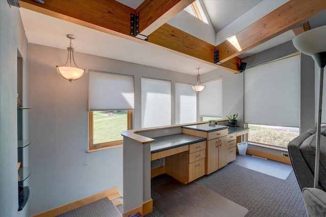 interior space featuring beam ceiling, dark tile patterned floors, pendant lighting, and light brown cabinets