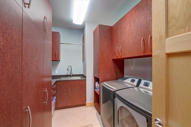 laundry room with sink, washing machine and clothes dryer, and cabinets