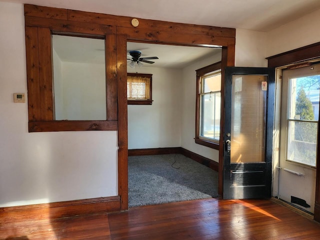 unfurnished room with ceiling fan and dark wood-type flooring