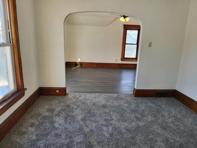 carpeted spare room with vaulted ceiling, ceiling fan, and a wealth of natural light