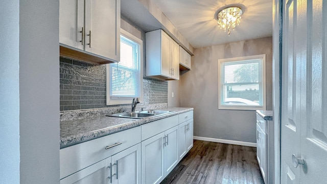 kitchen featuring white cabinets, backsplash, and sink