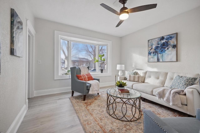 living room featuring ceiling fan and light hardwood / wood-style flooring