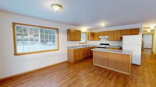 kitchen with white refrigerator, sink, a center island, light hardwood / wood-style flooring, and electric range