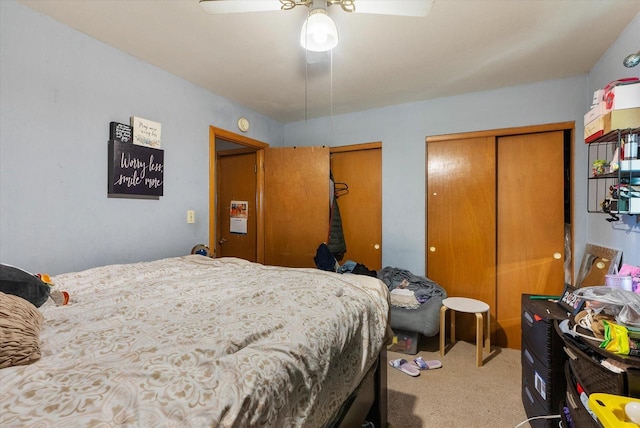 bedroom featuring multiple closets, ceiling fan, and carpet