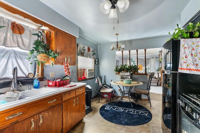 kitchen featuring black range oven, ceiling fan with notable chandelier, hanging light fixtures, and sink