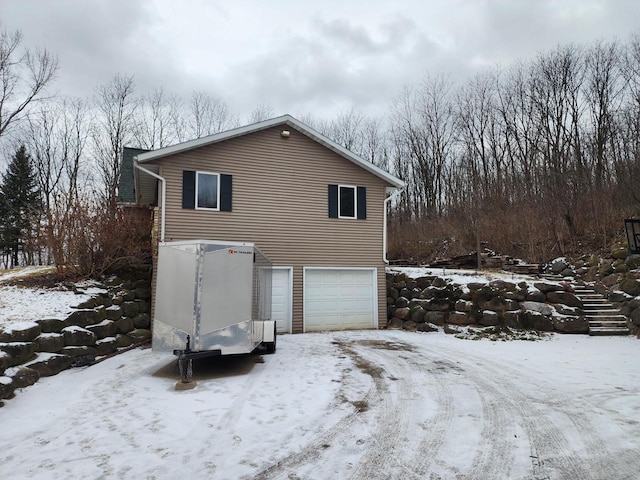 view of snowy exterior with a garage