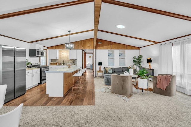 kitchen featuring sink, decorative light fixtures, white cabinetry, carpet, and appliances with stainless steel finishes