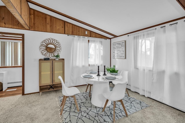 carpeted dining space featuring lofted ceiling, baseboard heating, and plenty of natural light