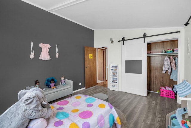 bedroom featuring vaulted ceiling, a closet, a barn door, and hardwood / wood-style floors